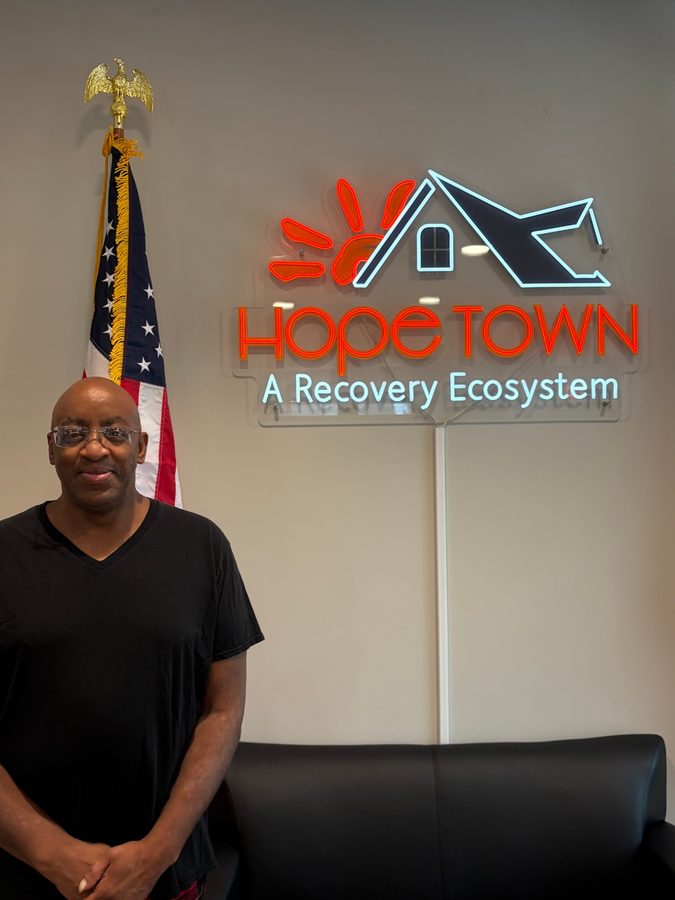 Terry, standing in front of the Hope Town sign.